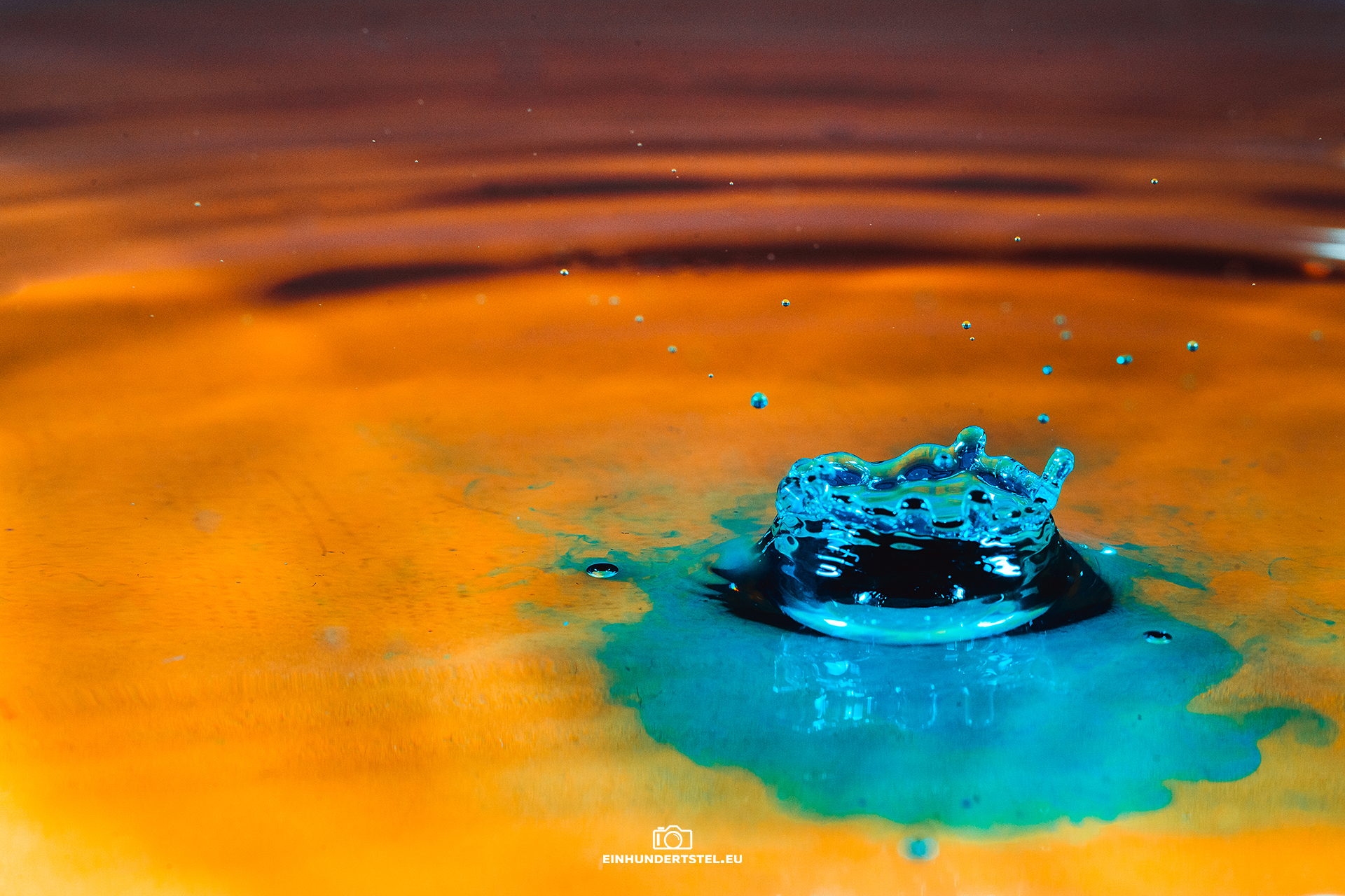 Blaue Wasserspritzer umgeben von goldenem Wasser.